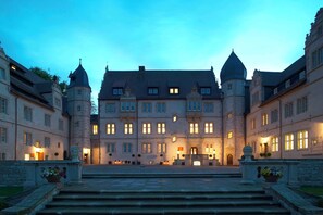Un grand bâtiment historique doté de nombreuses tours et d’une entrée centrale.