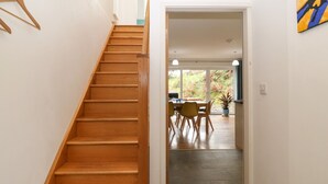 A wooden staircase leading to a dining area with a table and chairs. - Hen Gapel (Caernarfon)