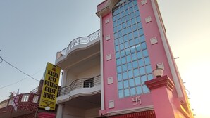 Un edificio rosa con un letrero que dice Kashi Nest Paying Guest House.