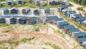 A residential area with modern houses, a winding road, and construction activity. - Lake Views Hot Tub Sauna Arcade Decks Family Stay (Branson)