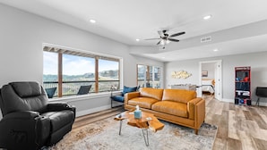 A modern living room with a leather sofa, a recliner, and a coffee table. - Lake Views Hot Tub Sauna Arcade Decks Family Stay (Branson)