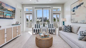A spacious living room with a large window, a ceiling fan, and a view of the outside.
