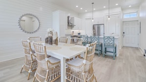 A modern kitchen with white cabinetry, a central island, and pendant lighting.