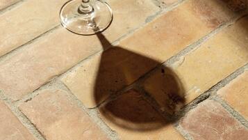 A martini glass with a frothy top on a tiled floor.