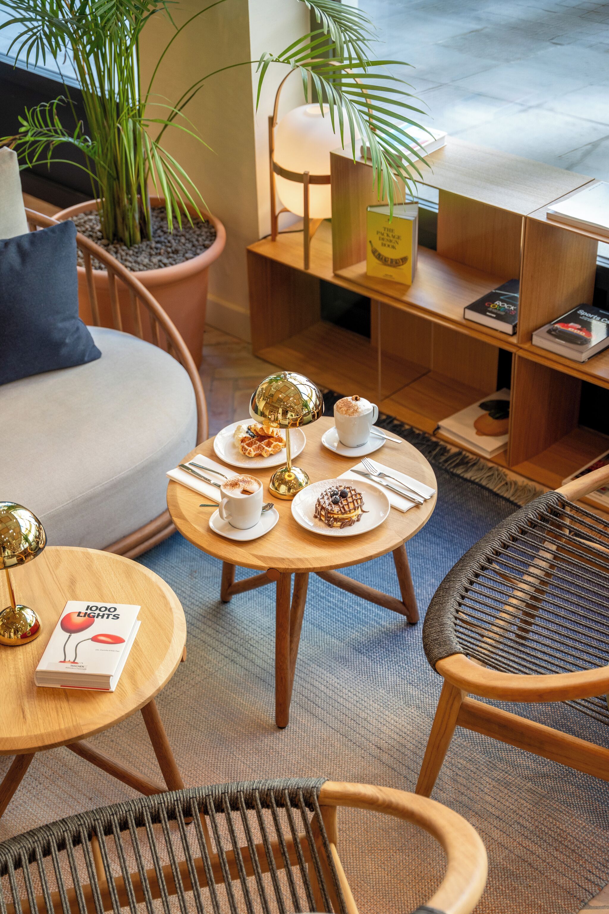A cozy seating area with a round table, chairs, and a potted plant.