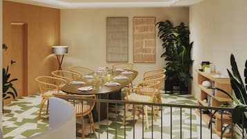 A dining area with a round table, wicker chairs, and a patterned floor.