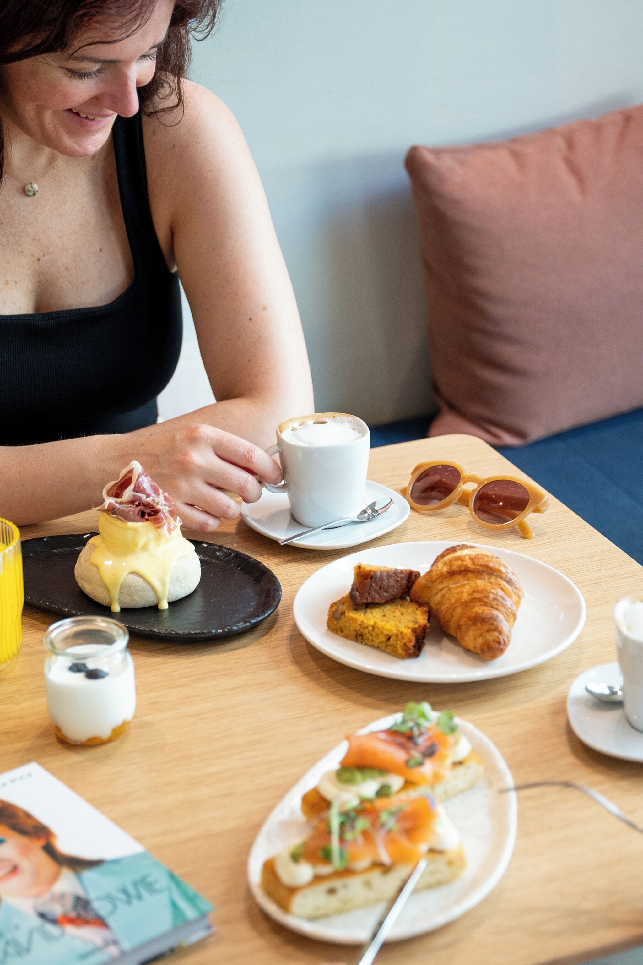 Une table dressée pour le petit-déjeuner, avec une variété d’aliments, notamment des œufs, des viennoiseries et une boisson.