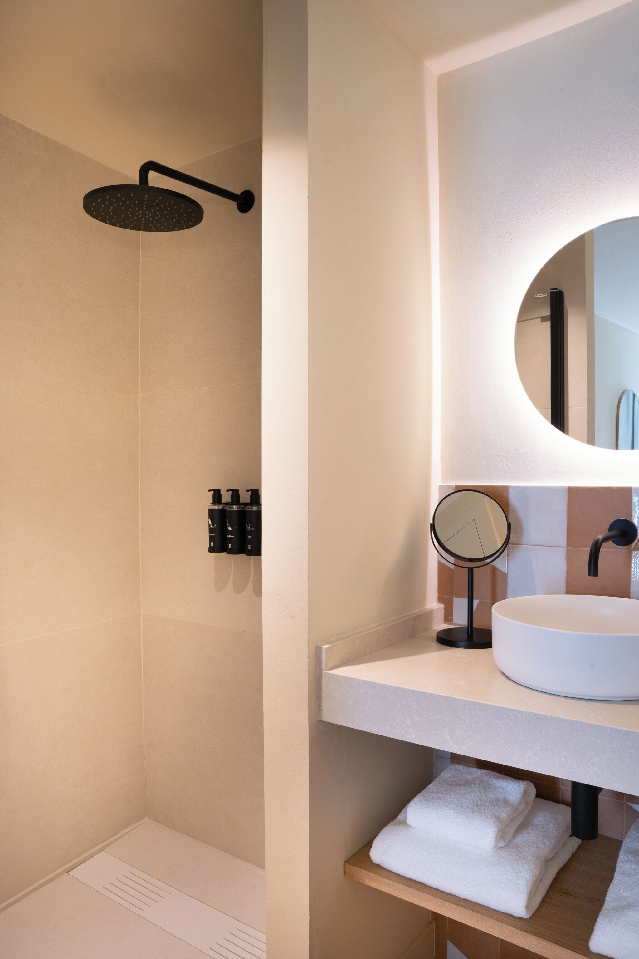 A modern bathroom with a shower, a sink, and a mirror.