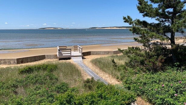 A beach with a wooden bench and a concrete barrier. - Stunning Waterfront in Wellfleet (CS0024) (Wellfleet)