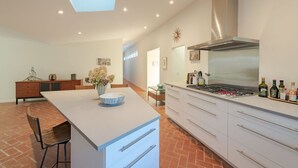 A modern kitchen with a central island, white cabinetry, and a skylight. - Newly Reno'd GORGEOUS, Water View, Beach Access (CS0034) (Wellfleet)