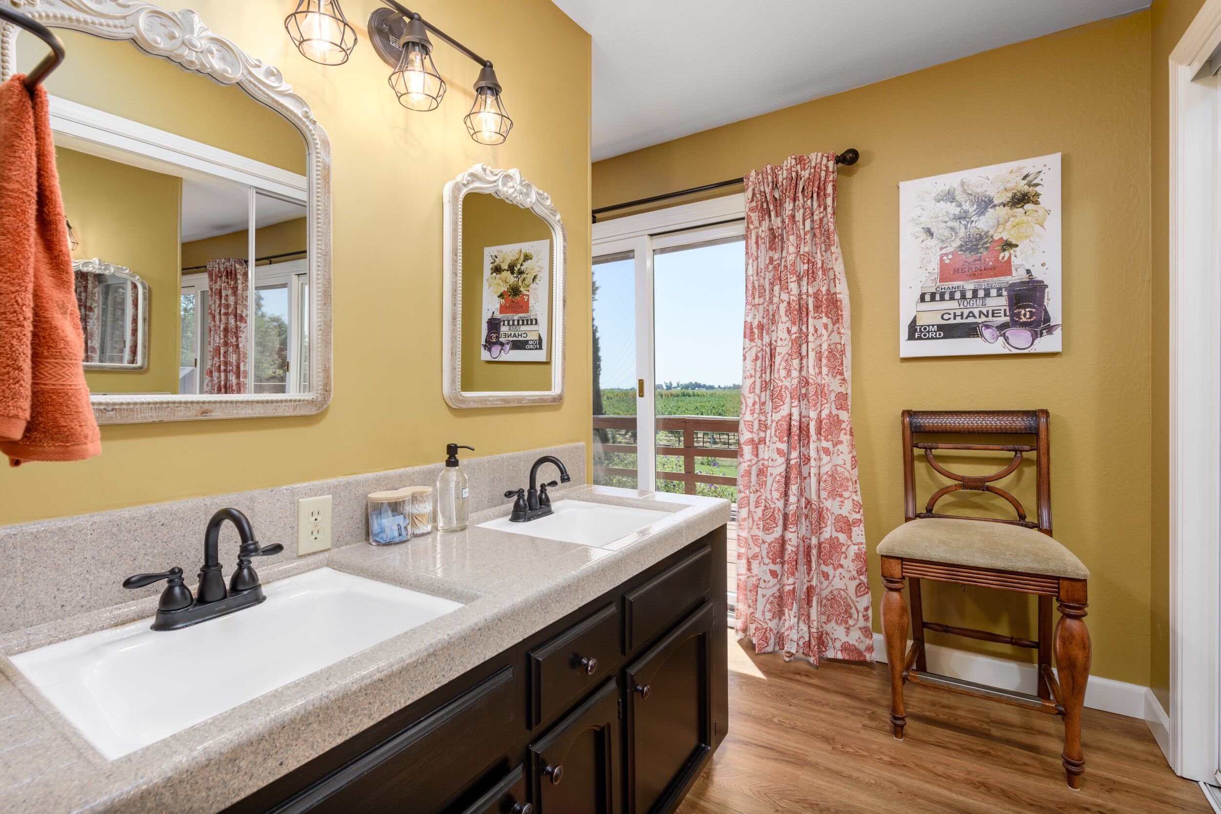 A bathroom with two sinks, a mirror, and a chair.