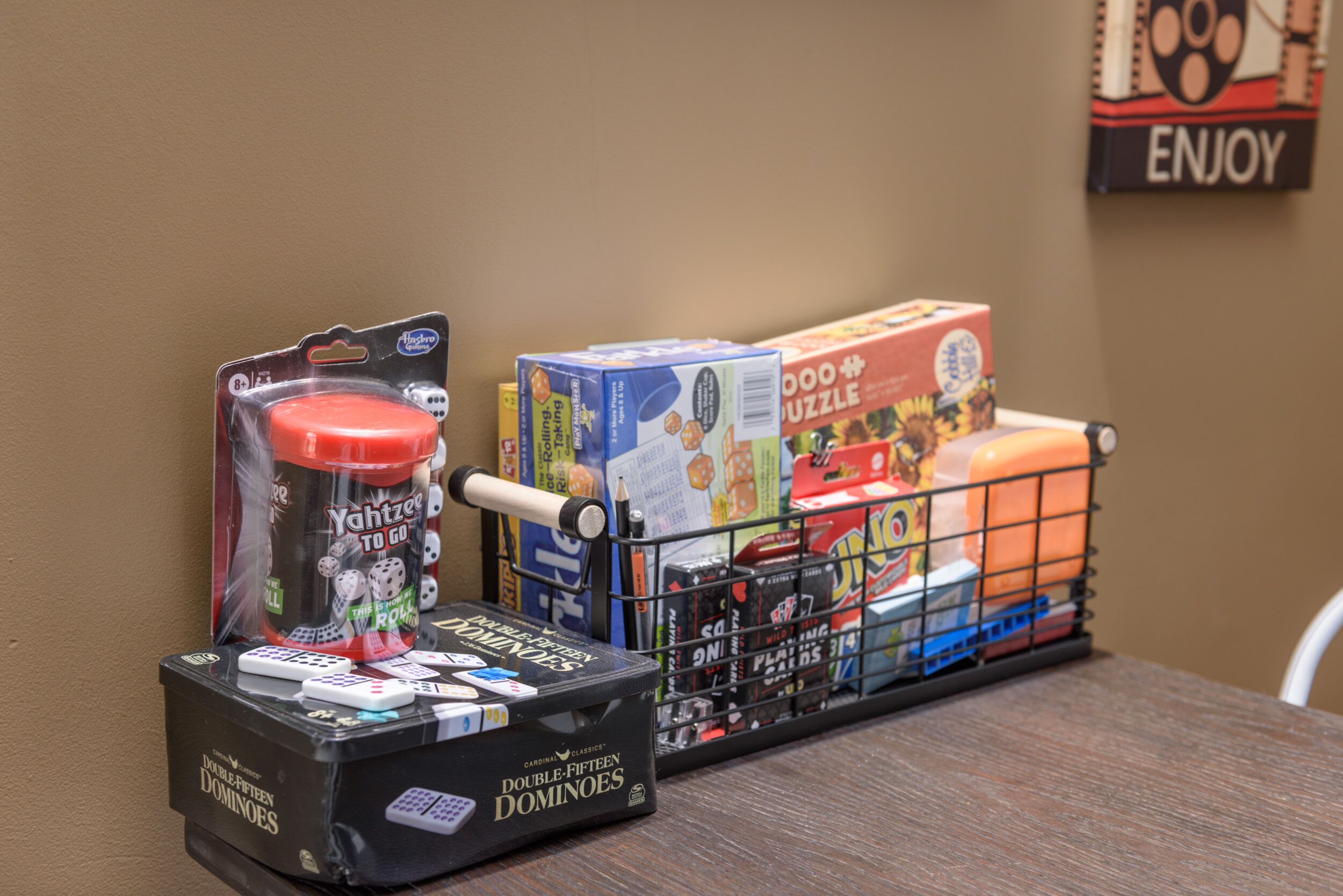 A table with a box of Double-Fifteen Dominoes, a Yahtzee game, and a board game.