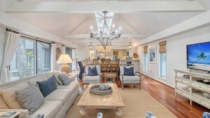 A spacious living area with a sofa, chairs, a coffee table, and a television. - Walk in minutes to Kiawah's famous beach! (Kiawah Island)