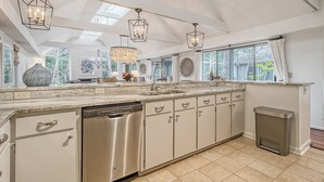 A spacious kitchen with a dishwasher, large windows, and pendant lighting. - Walk in minutes to Kiawah's famous beach! (Kiawah Island)