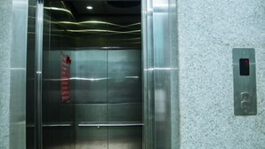 An elevator interior with metallic walls, a digital display, and a red safety sign. - Yaksa Hotel Pvt. Ltd. (Kathmandu)