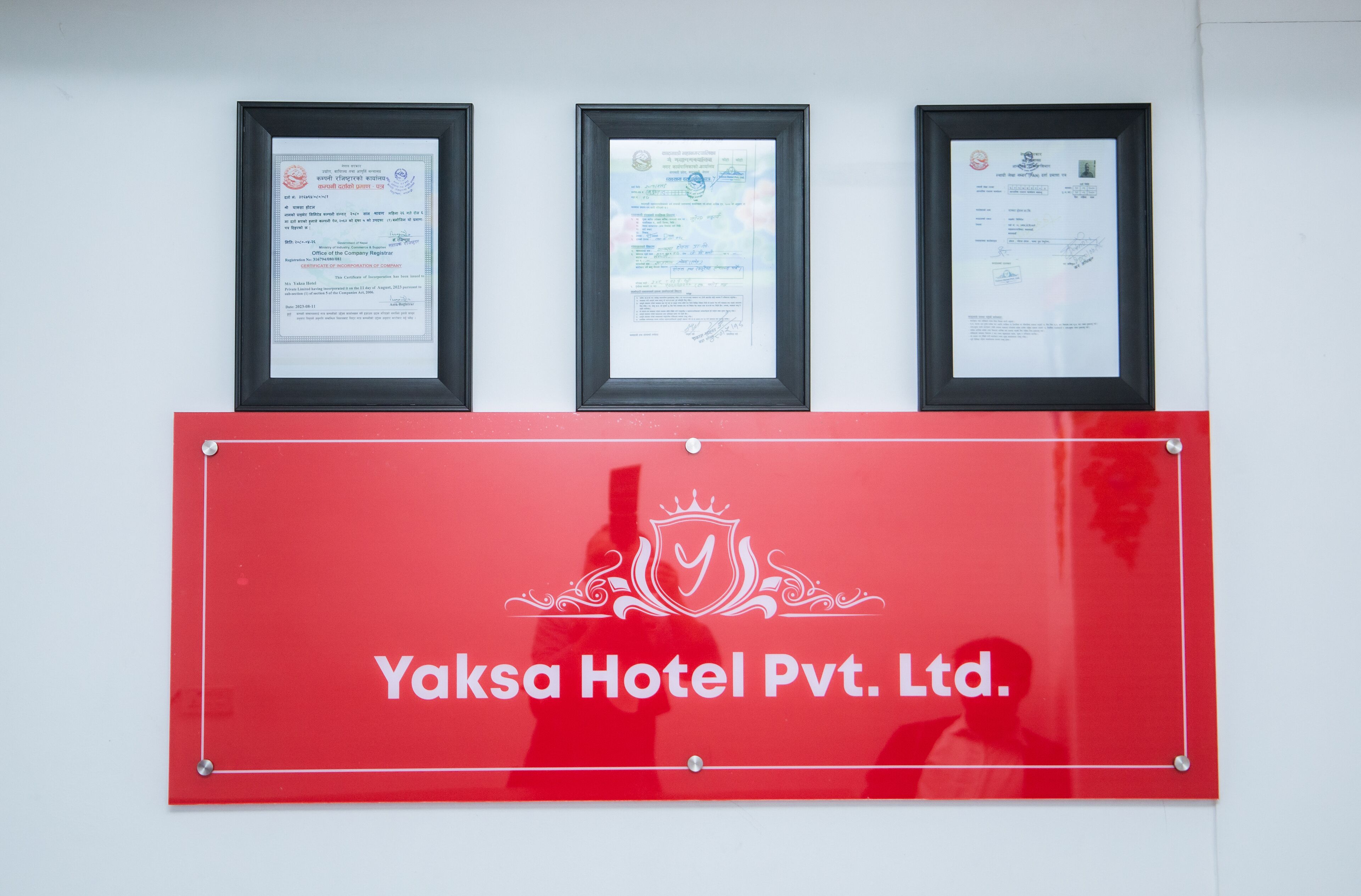 Three framed documents above a red sign with the text "Yaksa Hotel Pvt. Ltd."