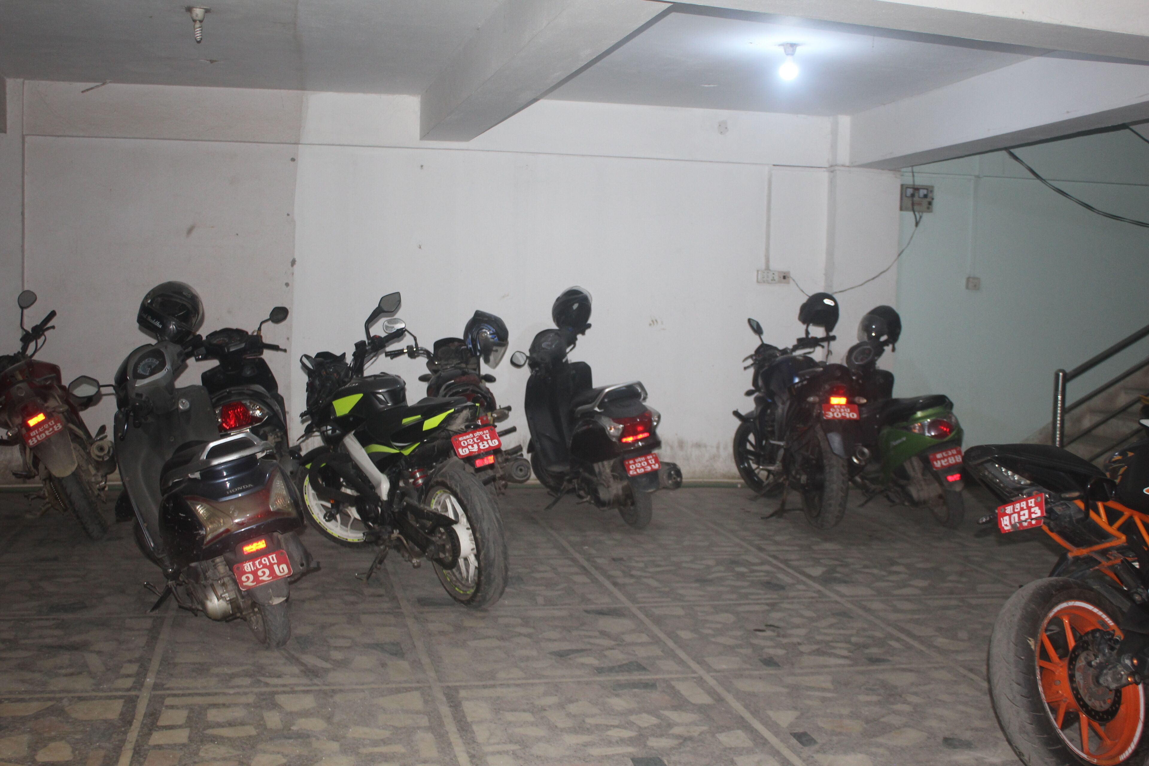 Un espace de stationnement où plusieurs motos sont garées à la suite.