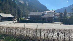 A building with a sloped roof, surrounded by a parking lot and a vineyard.