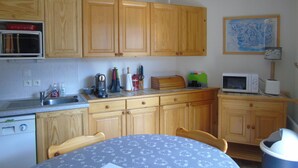 A small kitchen with wooden cabinets, a microwave, a toaster, and a sink.