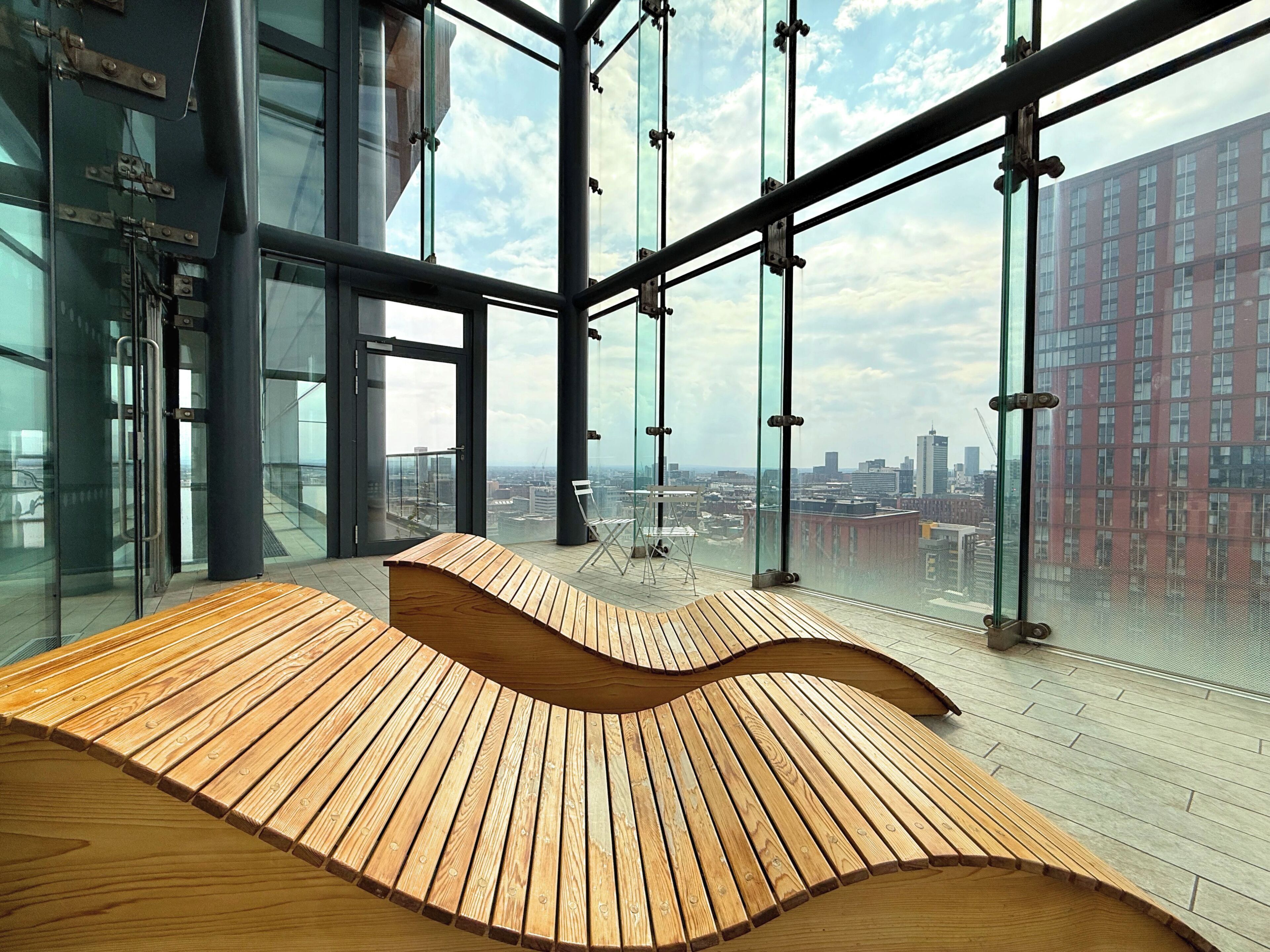 Un intérieur moderne avec un banc en bois aux lignes courbes et de grandes fenêtres donnant sur la ville.