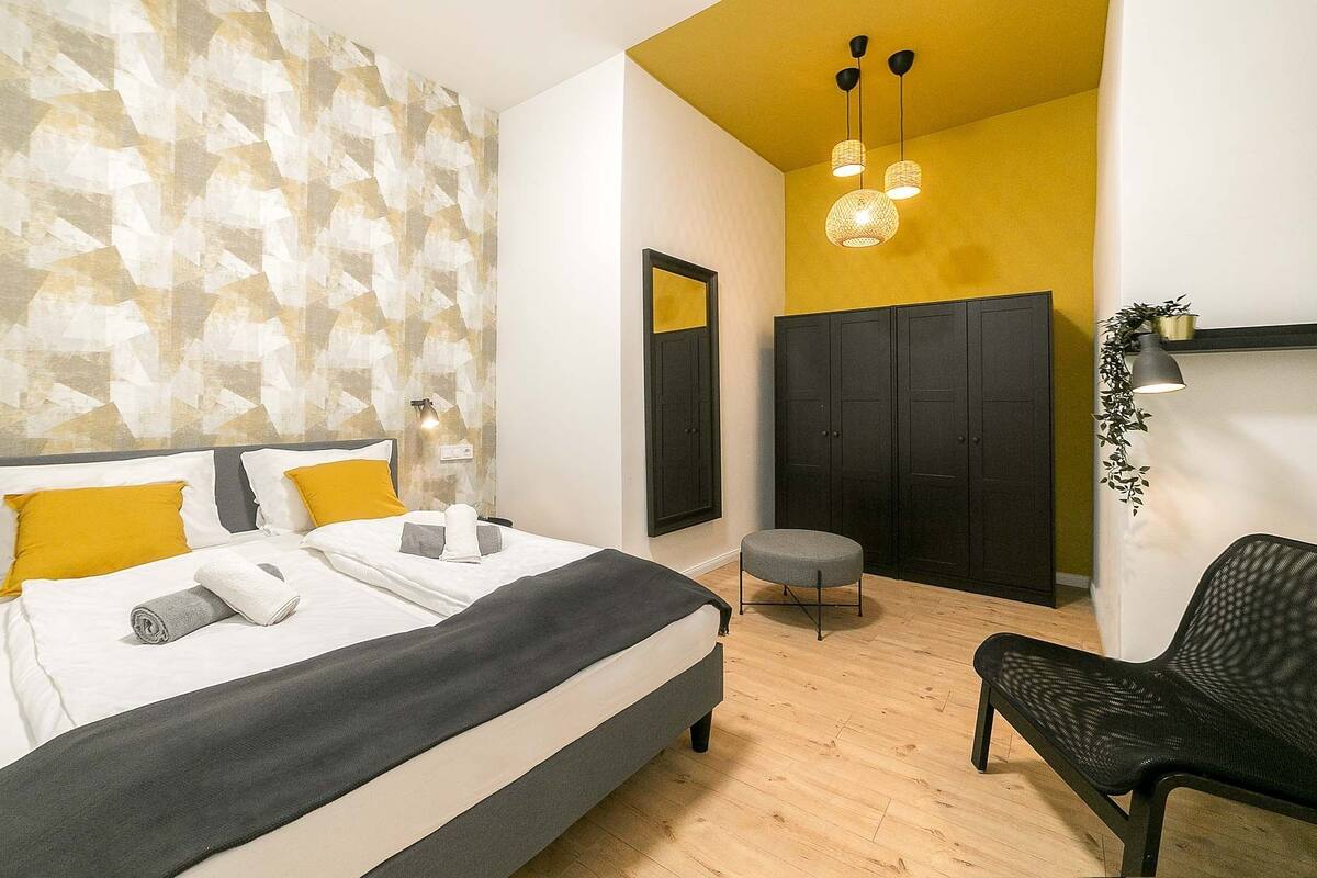 Une chambre à coucher moderne avec un lit, une table de chevet et une chaise.