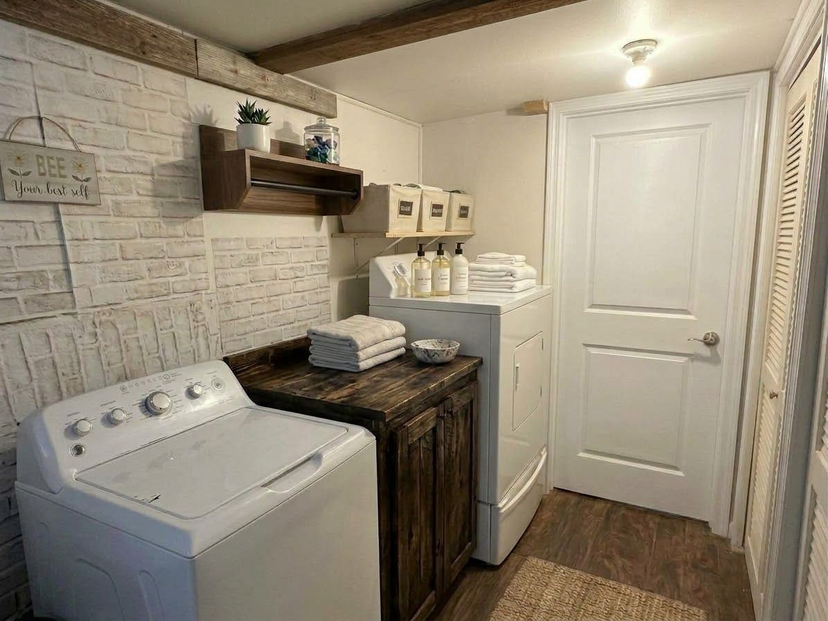 Un espace buanderie comprenant un lave-linge, un sèche-linge et des piles de serviettes.
