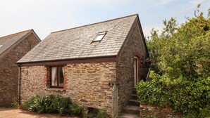 A small stone cottage with a sloped roof, a single window, and a door. - Higher Norton Barn (Totnes)