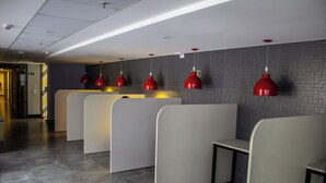 A modern waiting area with grey partitions and red pendant lights. - Complete studio in the center of Curitiba. (Centro Curitiba)