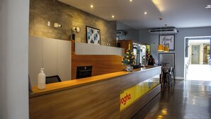 A reception area with a wooden counter, a Christmas tree, and a sign reading "Yogha." - Complete studio in the center of Curitiba. (Centro Curitiba)