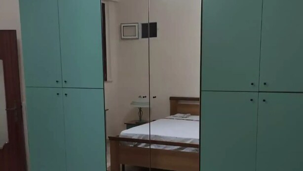 Una camera da letto con un letto, un armadio e uno specchio.