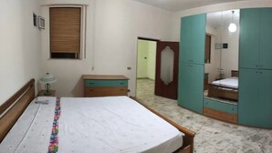 Una camera da letto con un letto, un comodino, una cassettiera e un armadio.