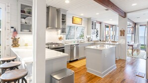 Een moderne keuken met witte kasten, roestvrijstalen apparatuur en een groot eiland.
