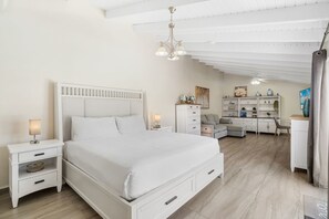 A bedroom with a bed, bedside tables, a desk, and a chair.