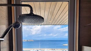 Ein Dachfenster mit Blick auf einen Yachthafen und das Meer.