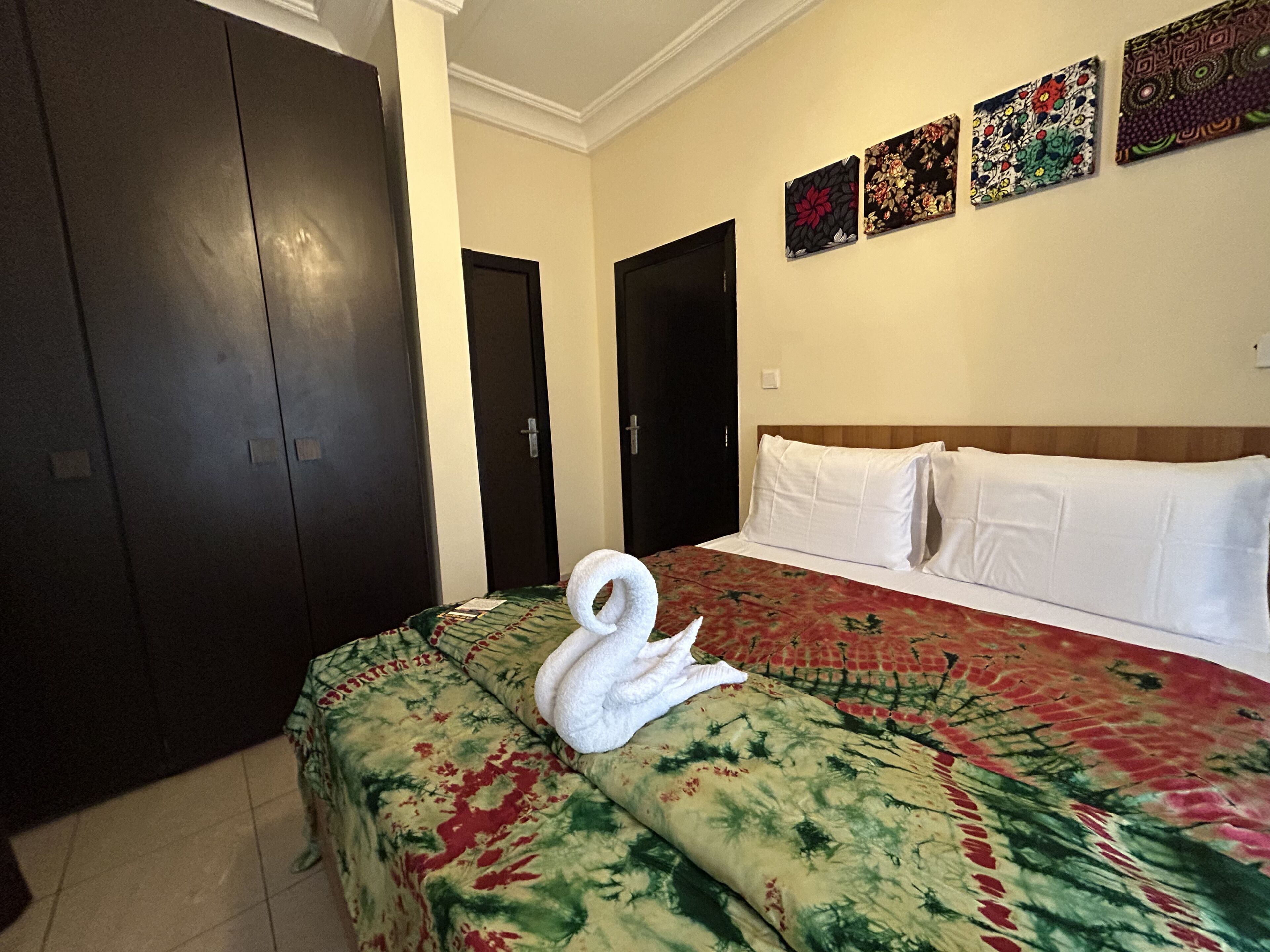 Een hotelkamer met een bed, een muur met kunst en een deur.