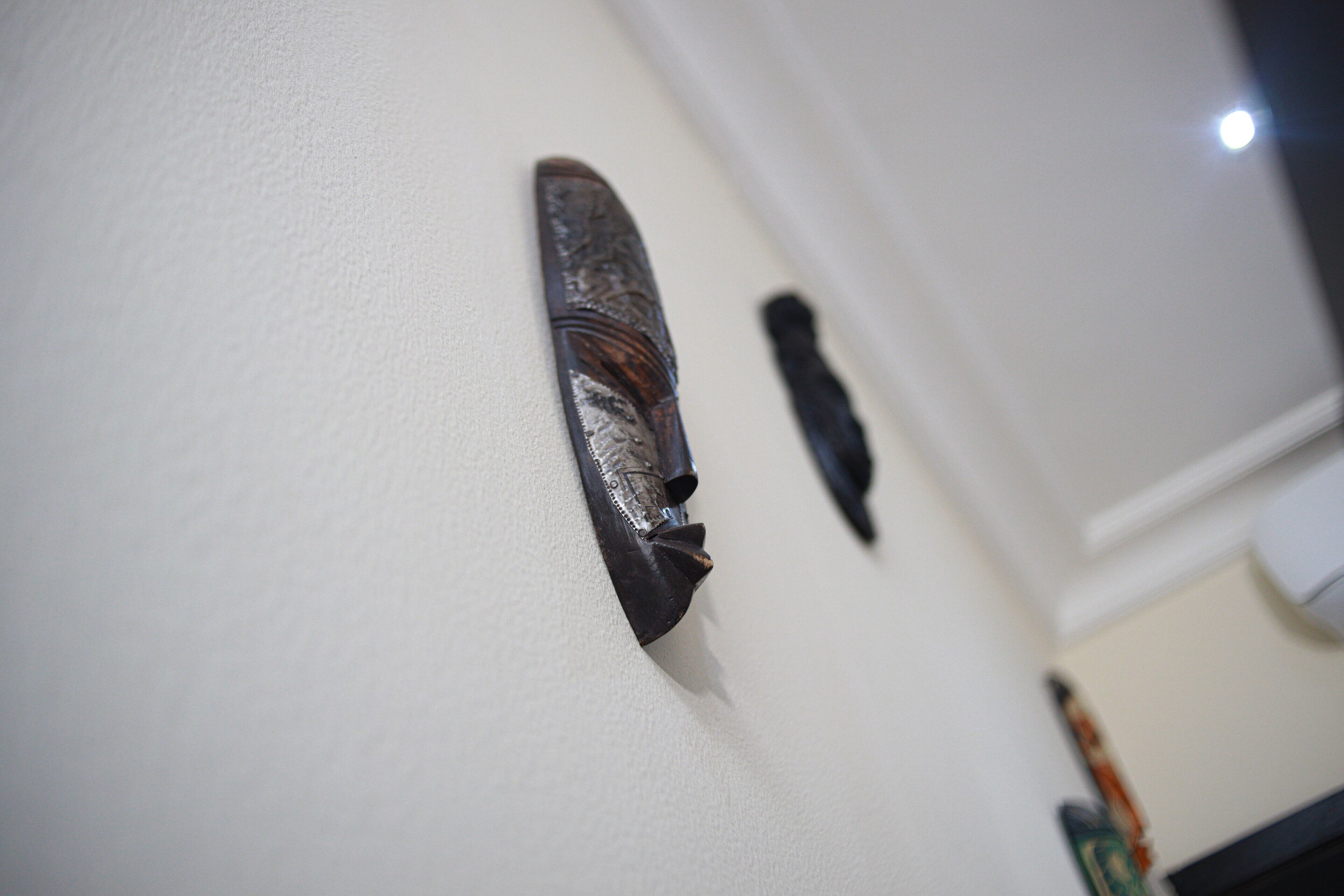 A wall with two wooden carvings.