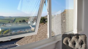 A room with a skylight, a radiator, and a view of a rural landscape. - Thornberry (Salcombe)