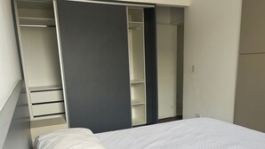 Ein Schlafzimmer mit einem Bett, einem Kleiderschrank und einem Schrank.