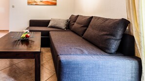 Una sala de estar moderna con un sofá modular, una mesa de centro y un cuadro en la pared.