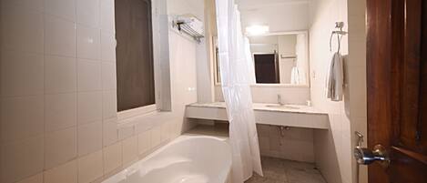 A bathroom with a bathtub, a shower, a sink, and a toilet.