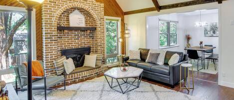 A spacious living room with a brick fireplace, a sofa, and a dining area.