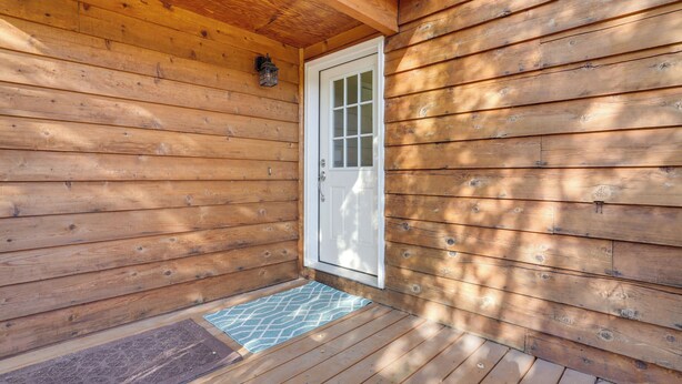 A wooden cabin with a white door and a small porch area. - Pet-friendly Anchorage Home - 8 Mi to Downtown! (Anchorage)