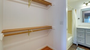 A bathroom with a wooden shelf, a white sink, and a shower curtain. - Pet-friendly Anchorage Home - 8 Mi to Downtown! (Anchorage)