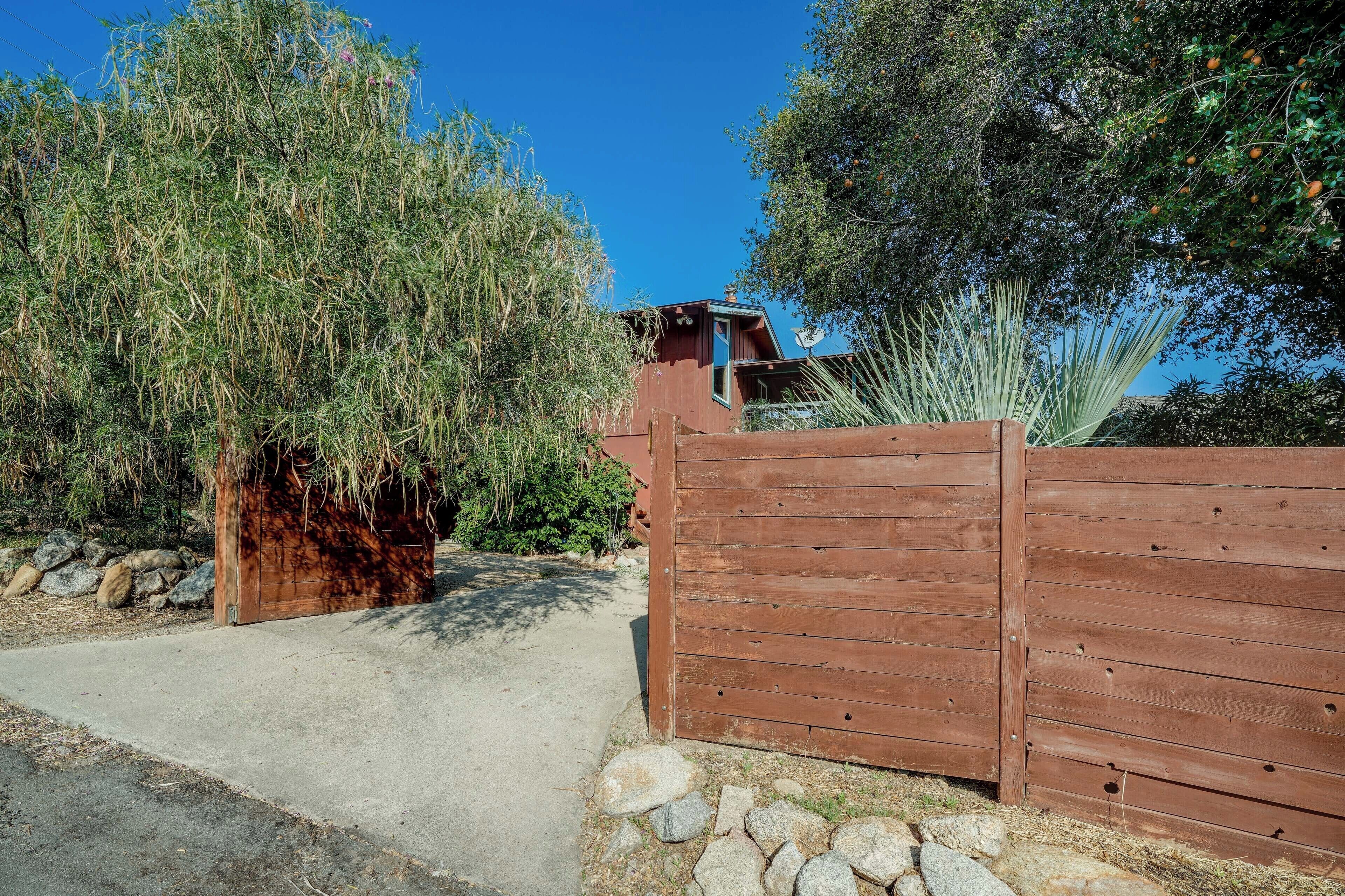 A wooden gate with a stone pathway leading to a building.