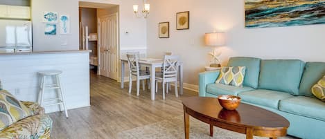Una sala de estar moderna con un sofá, una mesa de centro y un comedor con sillas y una mesa.