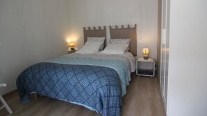 Una camera da letto con un letto, due comodini e due lampade a parete.