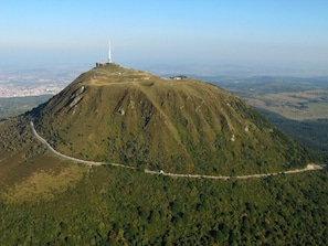 An aerial view of a mountain with a road winding around it and a white tower on top. - Puy de Dôme -Lovely country gite near Billom and Cournon d'Auvergne (Saint-Julien-de-Coppel)