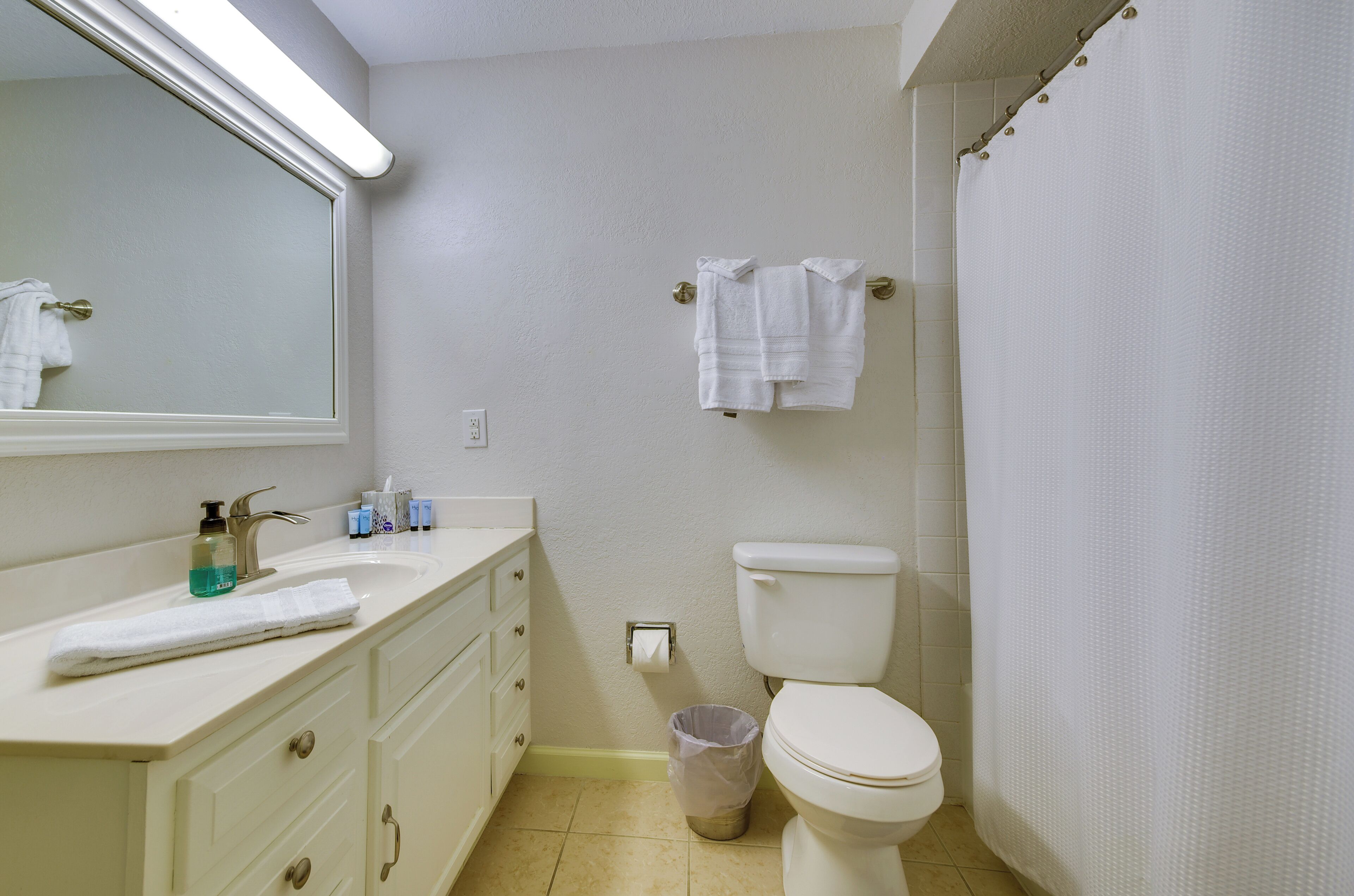Une salle de bain avec des toilettes, un lavabo et un miroir.