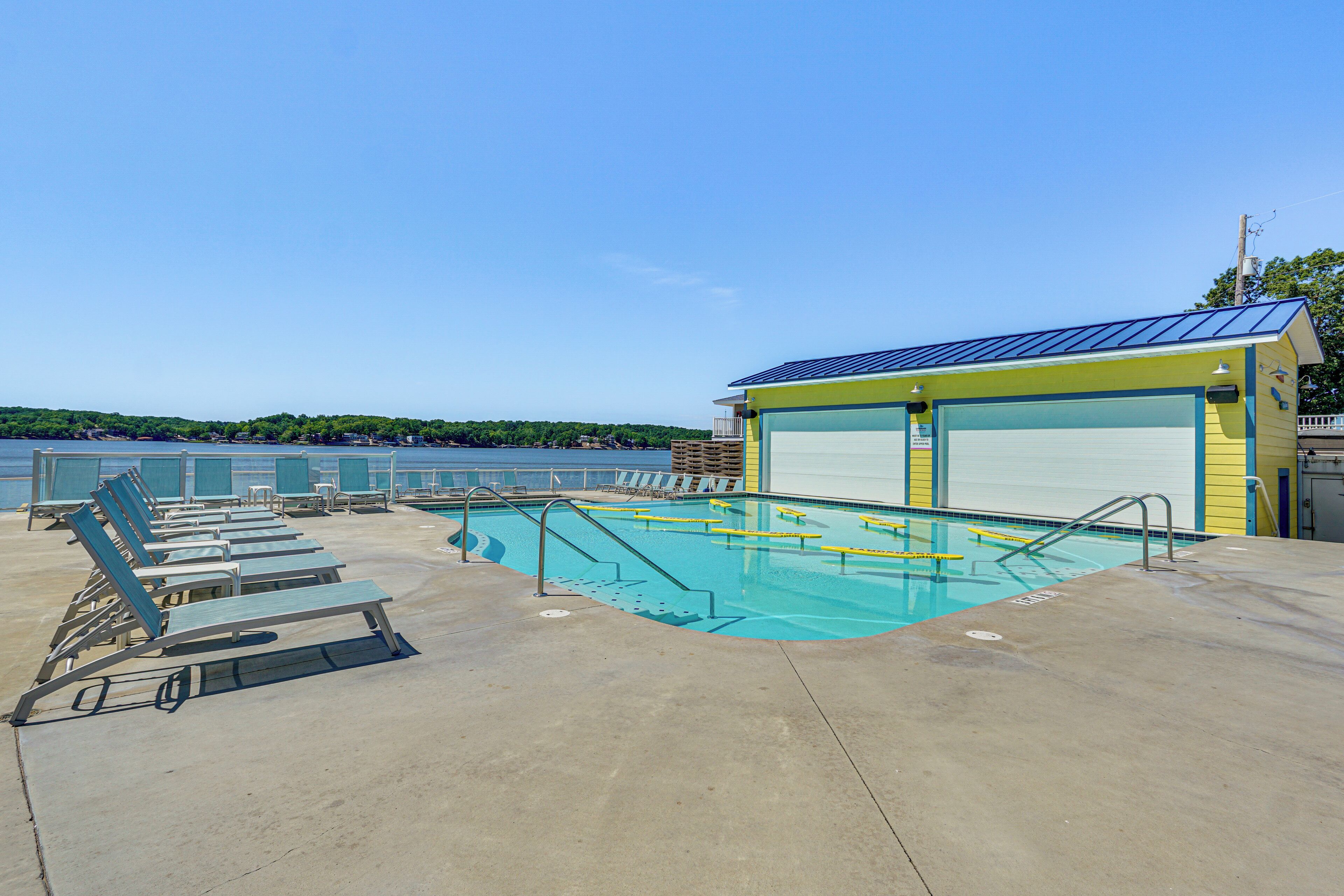 A pool area with lounge chairs and a lifeguard station.