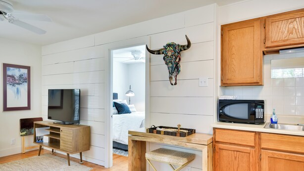 A modern kitchen with wooden cabinets, a microwave, and a decorative bull skull on the wall. - Convenient Lubbock Vacation Rental, 2 Mi to Ttu! (Lubbock)